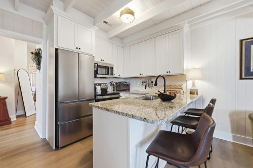 a kitchen with white cabinets and stainless steel appliances at Sunny Beach Bungalow Pet Friendly Near Beach in Myrtle Beach