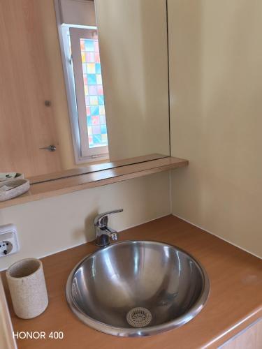 a sink in a bathroom with a mirror above it at Mobil home au bord du lac de Foix in Foix