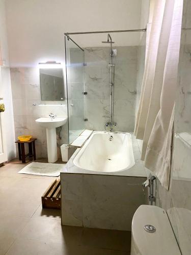 a bathroom with a bath tub and a sink at Malwatte Bungalows in Hali Ela