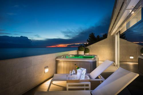 a balcony with a table and chairs and a tub at RIVALMARE Beach Boutique Hotel - NEW! in Novigrad Istria