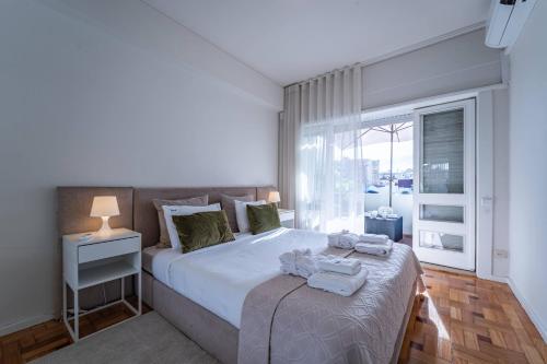 a bedroom with a large bed with towels on it at Brittos Avenue Apartment in Gaia in Vila Nova de Gaia