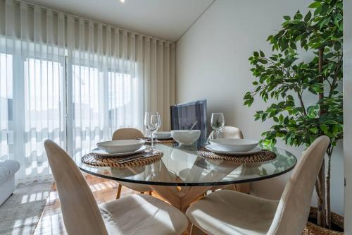 a dining room with a glass table and chairs at Brittos Avenue Apartment in Gaia in Vila Nova de Gaia