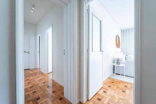 a hallway with white walls and a wooden floor at Brittos Avenue Apartment in Gaia in Vila Nova de Gaia