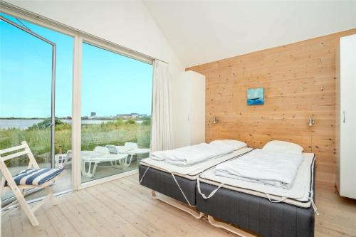 a bedroom with a bed and a balcony with a view at 702-Hvide-Sande-Slusen-2 in Hvide Sande