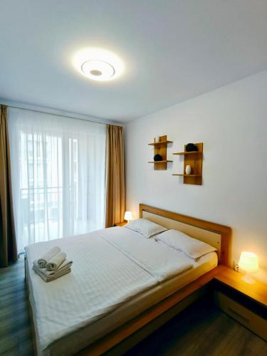 a bedroom with a bed with two lamps and a window at FLH - Apartament Central Silva in Sibiu