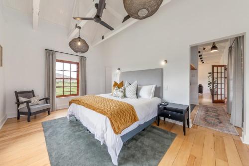 a bedroom with a large bed and a chair at Millstream manor guest house in Robertson