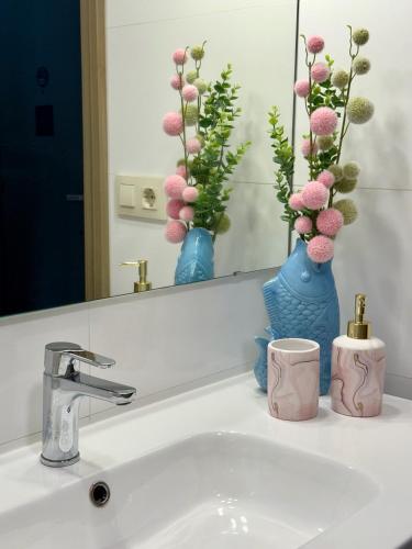 a bathroom sink with two blue vases and a mirror at Apartamento Cimadevilla Plaza in Oviedo