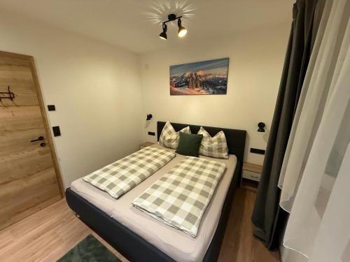 a bedroom with a bed with checkered pillows at Appartement Bergsicht in Leogang