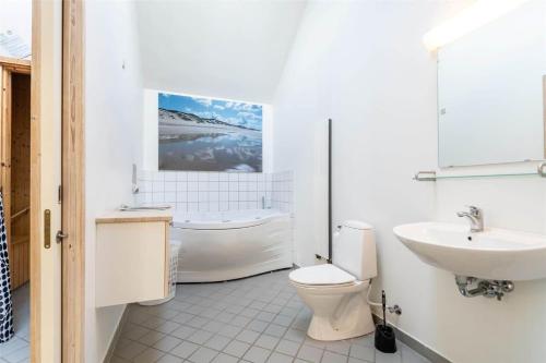 a bathroom with a toilet and a sink and a tub at 712-Hvide-Sande-Slusen-12 in Hvide Sande