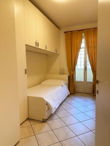 a bedroom with a bed and a tiled floor at Made in Langhe Apartment in La Morra