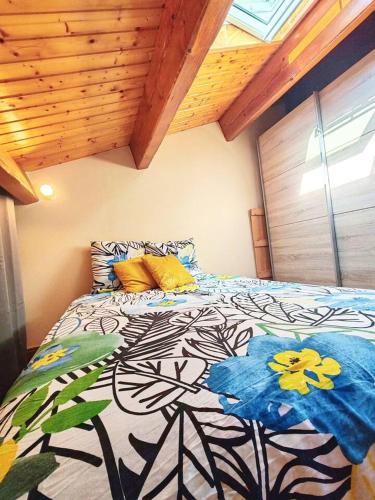 a bedroom with a bed with a flower pattern on it at Maison proche plage et commodités in Meschers-sur-Gironde