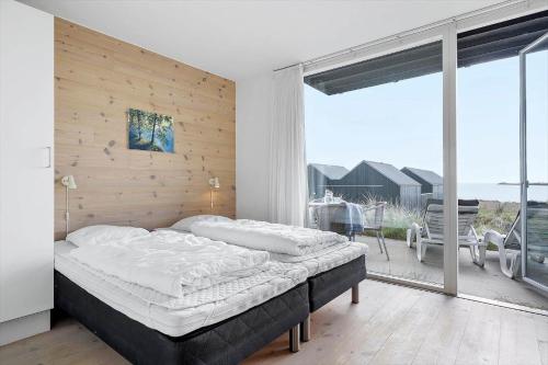 a bedroom with a large bed and a balcony at 718-Hvide-Sande-Slusen-18 in Hvide Sande