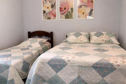 a bedroom with two beds and two pictures on the wall at Sítio casa das fadas em Pacoti in Pacoti