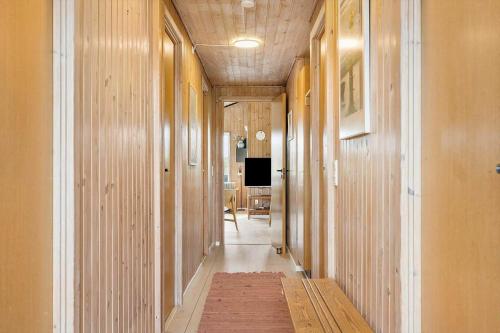 a hallway with wood paneled walls and a hallway with a television at 6606-Hvide-Sande-Arvidvej-164 in Bjerregård