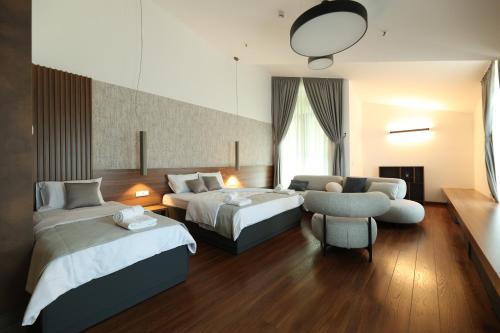 a hotel room with two beds and a chair at Terme BANJA LUKA in Banja Luka