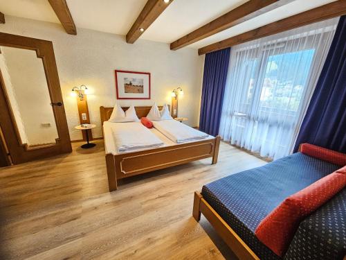 a hotel room with two beds and a window at Alpenlandhof in Bad Kleinkirchheim