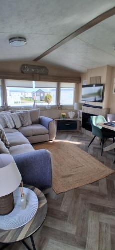 a living room with a couch and a table at The Beach House East Mersea in Mersea Island