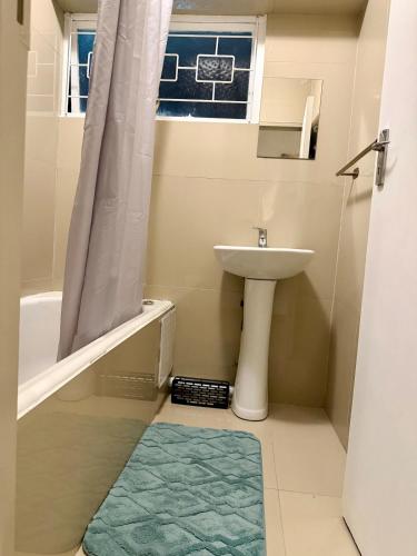 a bathroom with a sink and a toilet and a window at 2Bedroom Apartment in Pinetown