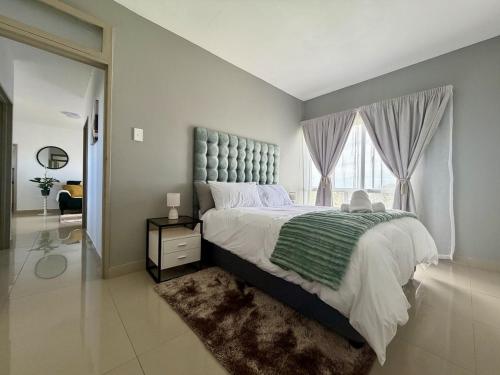 a bedroom with a large bed and a large window at 2Bedroom Apartment in Pinetown