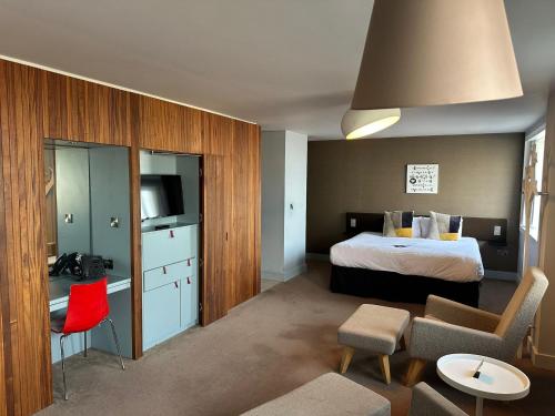 a hotel room with a bed and a red chair at The Midland in Morecambe
