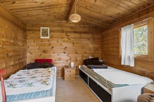 a bedroom with two beds in a log cabin at 3054-Stege-Stejlepladsen-12 in Stege