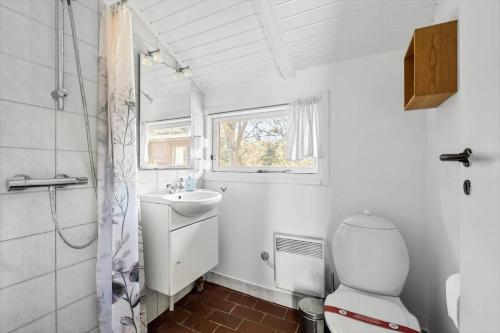 a bathroom with a toilet and a sink and a window at 3054-Stege-Stejlepladsen-12 in Stege