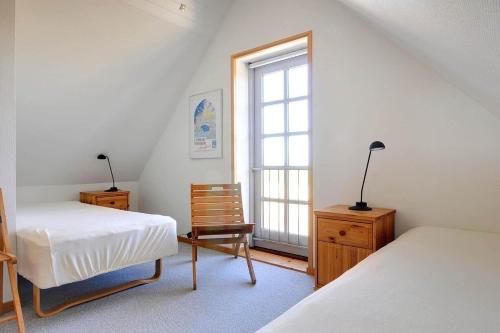 a attic bedroom with two beds and a window at 6306-Stege-Hjelmvej-24 in Stege