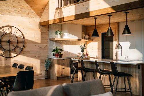 a kitchen with wooden walls and a table and chairs at Chalet Le Solem Golf et Spa in Saint-Faustin