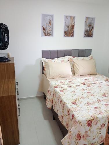 a bedroom with a bed and two paintings on the wall at top Suites in Saquarema