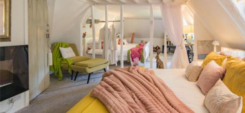 a bedroom with a large bed with a blanket on it at 16th Century Manor House in Richborough