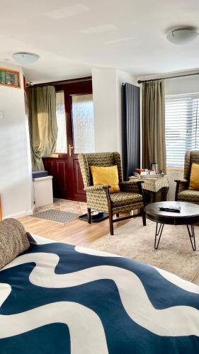 a living room with a bed and chairs and a table at East Cliff Folkestone Guest Suite With Own Entrance in Folkestone