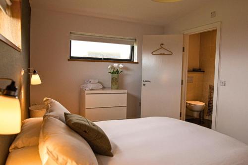 a bedroom with a bed with pillows and a window at Jog Lodge 22 By Together Travel - 3 Bed Sea-View in Wick