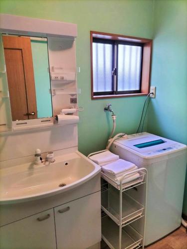 a bathroom with a sink and a mirror at さくらVillaCOAST in Futtsu