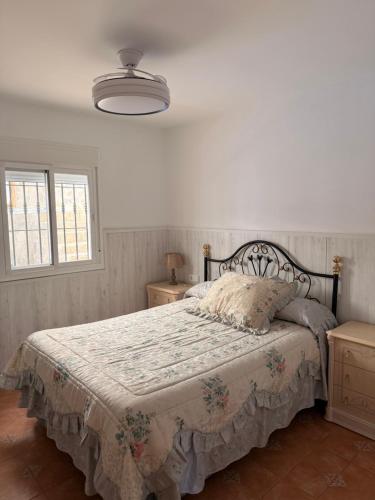 a bedroom with a bed with a floral bedspread at Casa rural Cristina- Piscina climatizada in Málaga