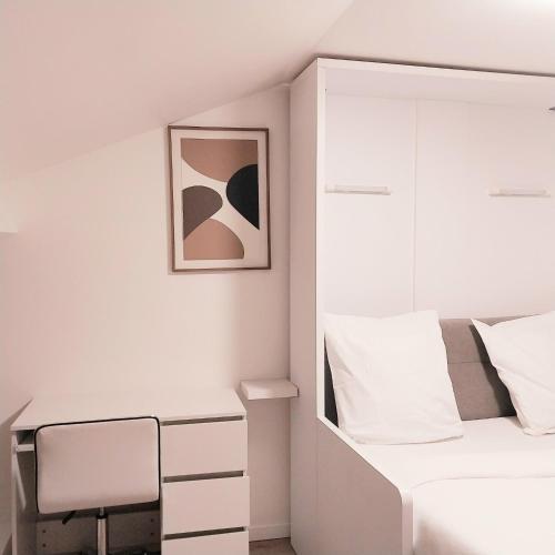a white bedroom with a bed and a desk at Top Studio Vincennes Centre - SV75 in Vincennes
