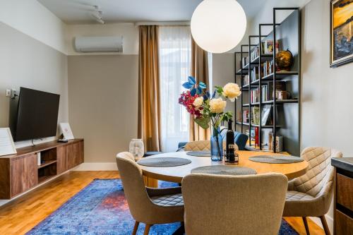 a living room with a table and chairs and a tv at The Nest in Ruse