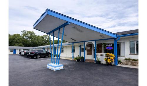 a building with blue columns in a parking lot at Holiday Motel Ocala Downtown I-75 in Ocala