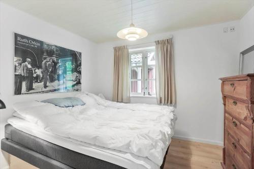 a bedroom with a large white bed and a dresser at 2031-Stege-Ulvshalevej-301 in Stege