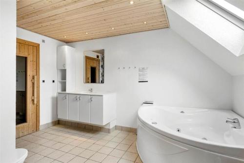a white bathroom with a tub and a sink at 1311-Stege-Rylevej-20 in Stege