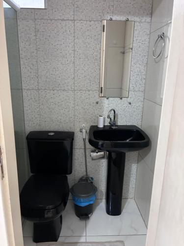 a bathroom with a black toilet and a sink at SR Hotel e Pousada Pirambu in Pirambu