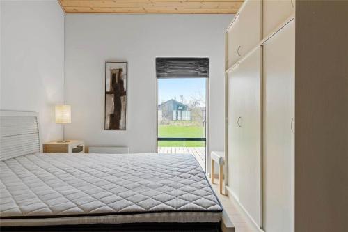 a bedroom with a bed and a door to a yard at 1306-Stege-Kaerhogevej-64 in Stege