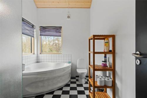 a bathroom with a large tub and a toilet at 1306-Stege-Kaerhogevej-64 in Stege
