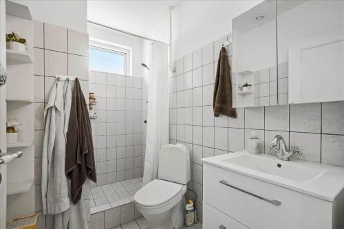 a white bathroom with a toilet and a sink at 4033-Stege-Kirkebakken-33 in Stege