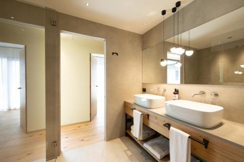a bathroom with two sinks and a mirror at Etra Suites & Apartments in Riva del Garda