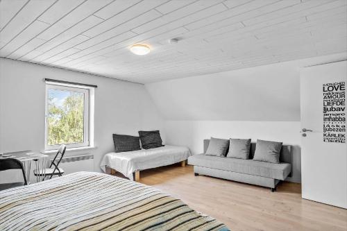 a bedroom with a bed and a couch and a window at 4019-Stege-Udbyvej-15 in Stege