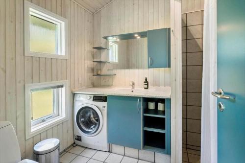 a bathroom with a washing machine and a sink at 1080-Stege-Berberisvej-48 in Stege