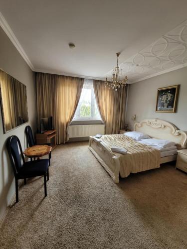 a bedroom with a bed and a table and a chair at Hotel Restauracja Małopolska in Jasło
