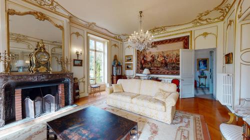 a living room with a couch and a fireplace at Chateau du boulay morin in Le Boulay-Morin