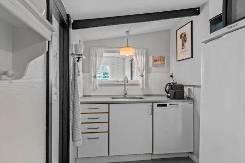 a white kitchen with a sink and a window at 8223-Vordingborg-Laekrogen-13 in Vordingborg