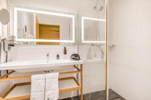 a bathroom with a sink and a mirror at Best Western Plus d'Europe et d'Angleterre in Mâcon